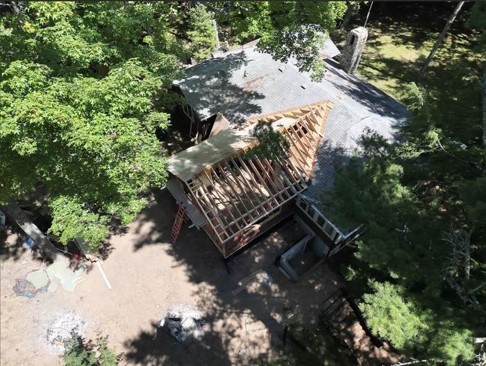 Aerial view of roof trusses framed against the tree line